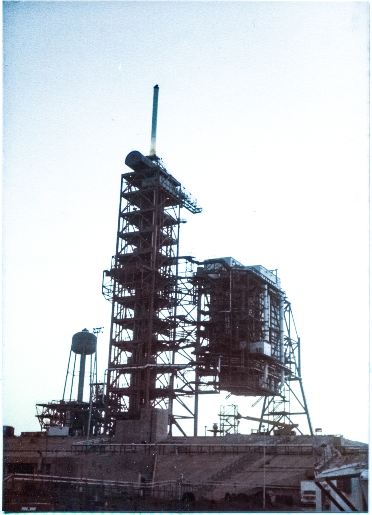 Image 048. The Rotating Service Structure at Space Shuttle Launch Complex 39-B, Kennedy Space Center, Florida, constructed by Union Ironworkers from Local 808 working for Wilhoit Steel Erectors, no longer exists in the position it had occupied during the years it was being built. Its first functional proof-test is complete, and it has smoothly traveled out over and across the Flame Trench to the position it will occupy when it mates with the Space Shuttles it was designed to service. Four million pounds of steel no longer sits where it once was, and now rests in a location where it has never been before. Photo by James MacLaren.
